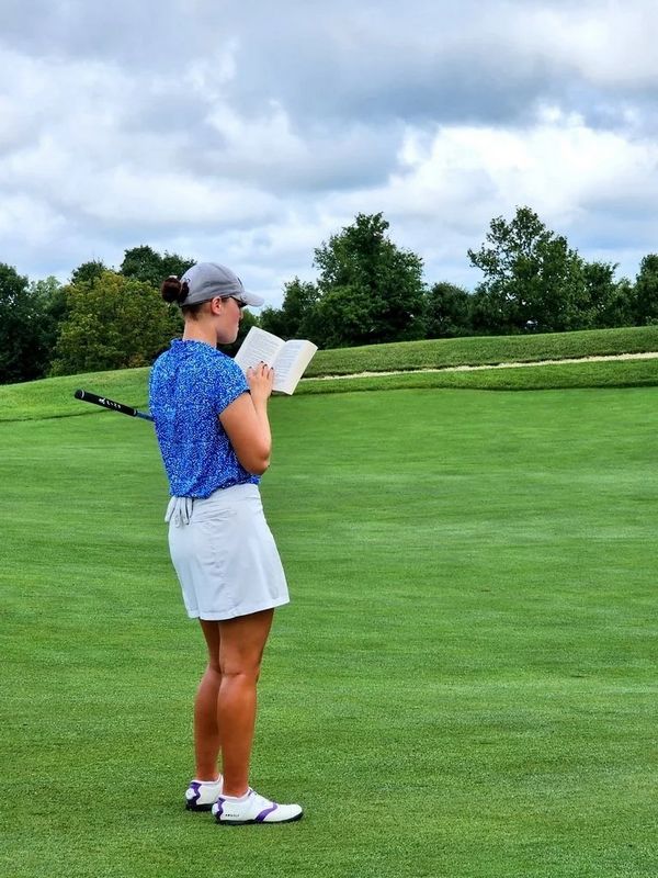 Nữ golfer tranh thủ đọc sách ngay trên fairway tại Epson Tour năm 2023. Ảnh: @LinksNation.